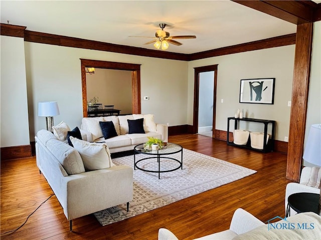 living room featuring crown molding, ceiling fan, hardwood / wood-style flooring, and baseboards