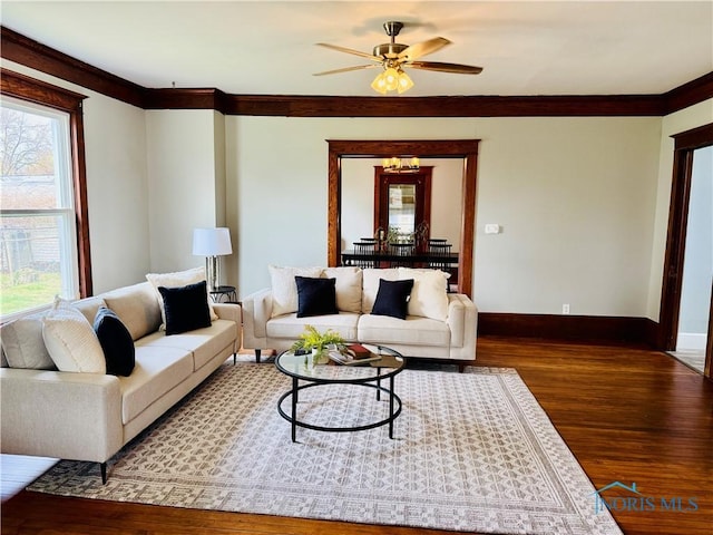 living room featuring wood finished floors, a healthy amount of sunlight, a ceiling fan, and baseboards