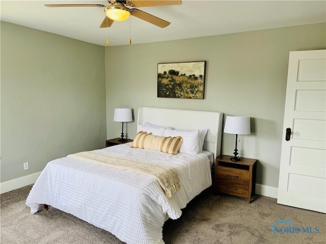carpeted bedroom with ceiling fan and baseboards