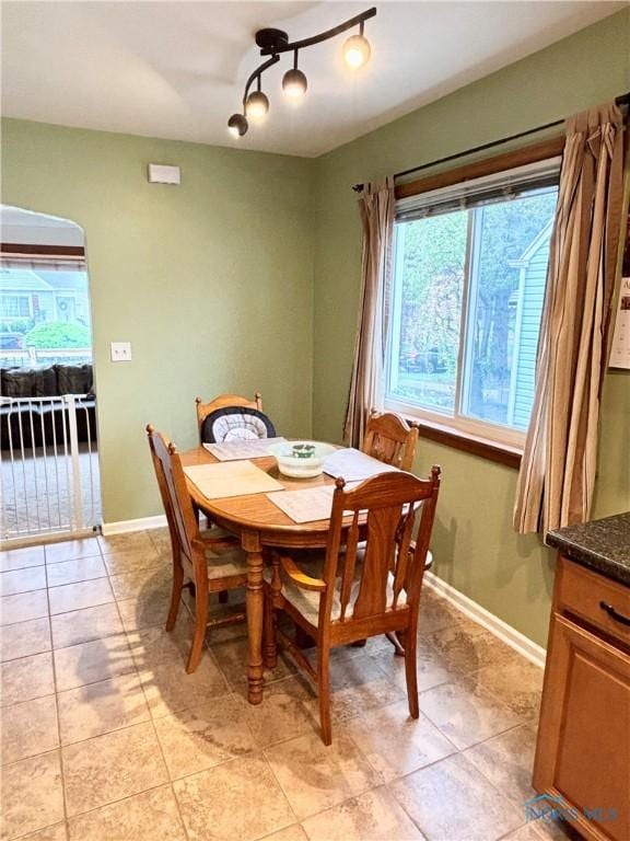 dining space with light tile patterned flooring and baseboards