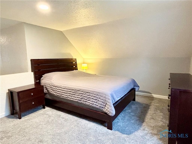 bedroom with lofted ceiling, carpet, a textured ceiling, and baseboards