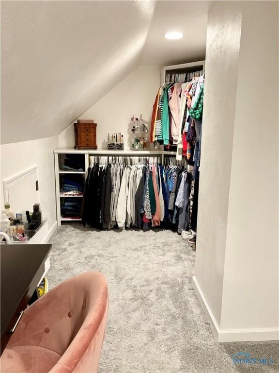 walk in closet with carpet flooring and vaulted ceiling