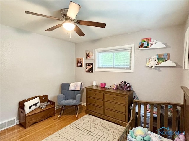 bedroom with wood finished floors, visible vents, ceiling fan, and baseboards