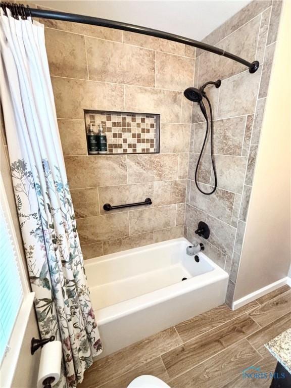 bathroom featuring shower / bathtub combination with curtain, wood tiled floor, and baseboards