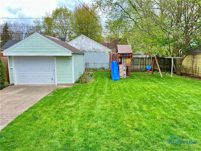 view of yard featuring an outdoor structure, a detached garage, driveway, a playground, and fence