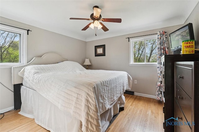 24203 W Reservation Line Rd, Curtice, OH 43412 - bedroom with baseboards, multiple windows, and light wood-style flooring