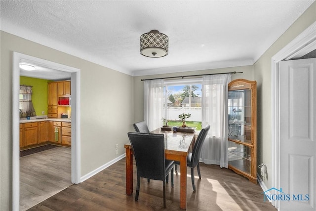 dining room featuring dark wood finished floors and baseboards