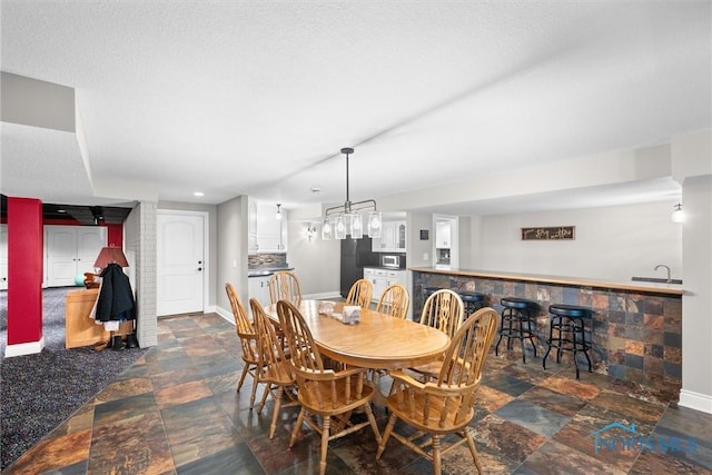 10915 Reed Rd, Monclova, OH 43542 - dining room featuring baseboards, stone finish flooring, and bar