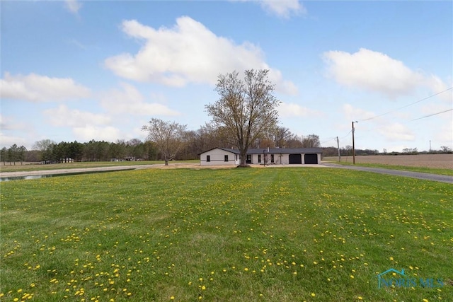 view of yard featuring driveway and an attached garage