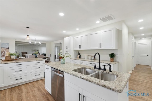 kitchen with visible vents, stainless steel dishwasher, white cabinets, and a sink