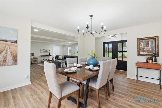 dining area featuring recessed lighting, an inviting chandelier, light wood finished floors, baseboards, and french doors