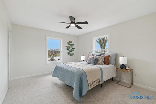 carpeted bedroom featuring ceiling fan and baseboards