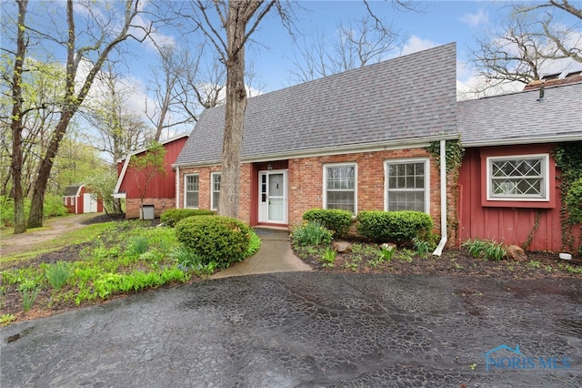 19788 Otsego Pike, Bowling Green, OH 43402 - cape cod house with board and batten siding, an outdoor structure, brick siding, a shingled roof, and a storage shed