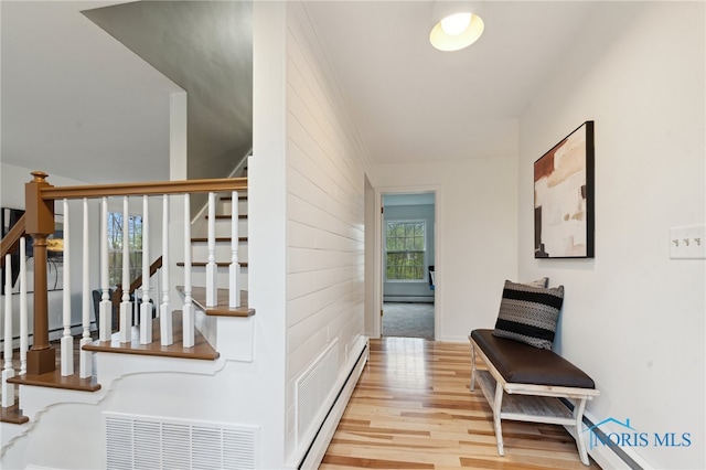 19788 Otsego Pike, Bowling Green, OH 43402 - corridor featuring stairway, visible vents, baseboard heating, wood finished floors, and a baseboard radiator