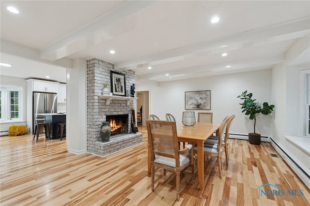 19788 Otsego Pike, Bowling Green, OH 43402 - dining room featuring light wood finished floors, recessed lighting, beam ceiling, a brick fireplace, and a baseboard radiator