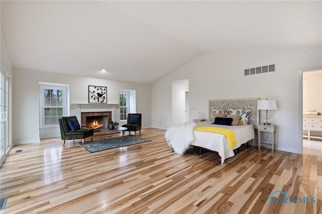 19788 Otsego Pike, Bowling Green, OH 43402 - bedroom featuring visible vents, wood finished floors, a brick fireplace, and vaulted ceiling
