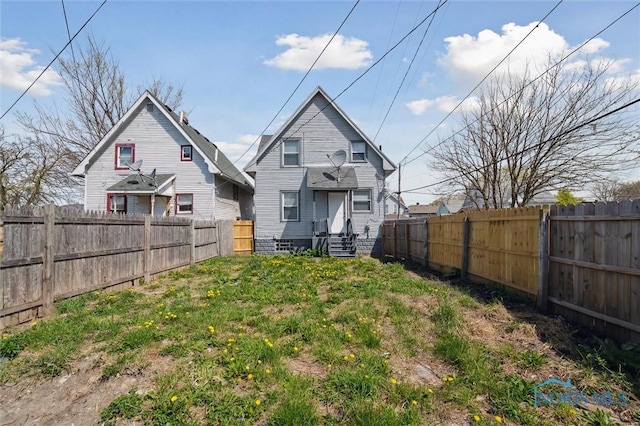 rear view of house featuring a fenced backyard and entry steps