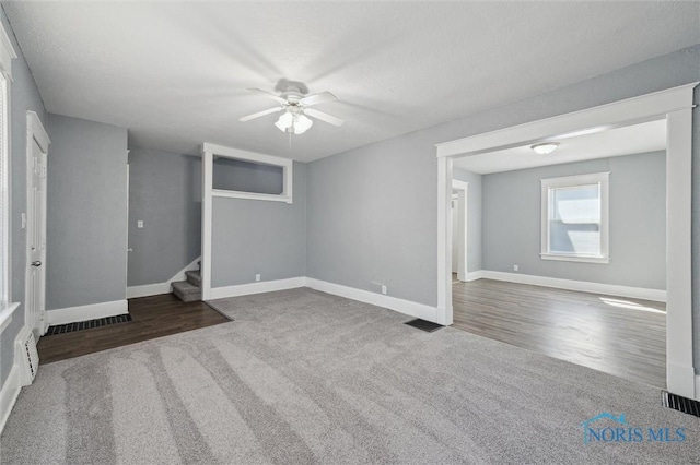 interior space featuring stairway, ceiling fan, visible vents, and baseboards