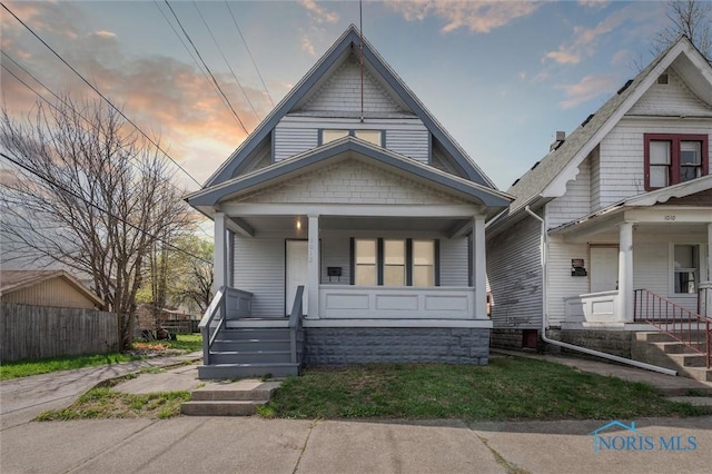 view of front of property with fence and a porch