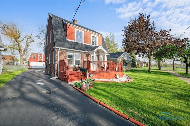 4532 290th St, Toledo, OH 43611 - dutch colonial with a garage, brick siding, a front lawn, a wooden deck, and an outbuilding