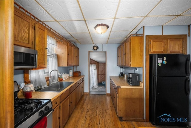 4532 290th St, Toledo, OH 43611 - kitchen with appliances with stainless steel finishes, a sink, brown cabinetry, and light countertops