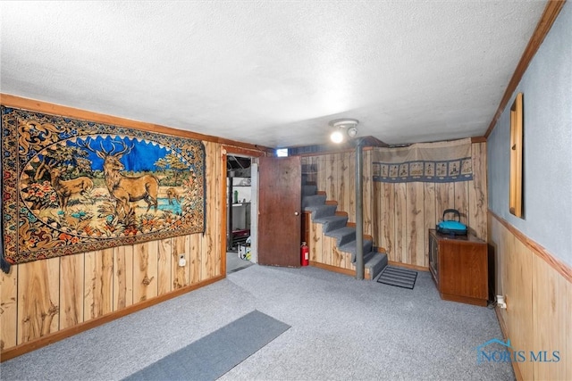 4532 290th St, Toledo, OH 43611 - finished basement featuring a textured ceiling, wooden walls, carpet floors, and stairs