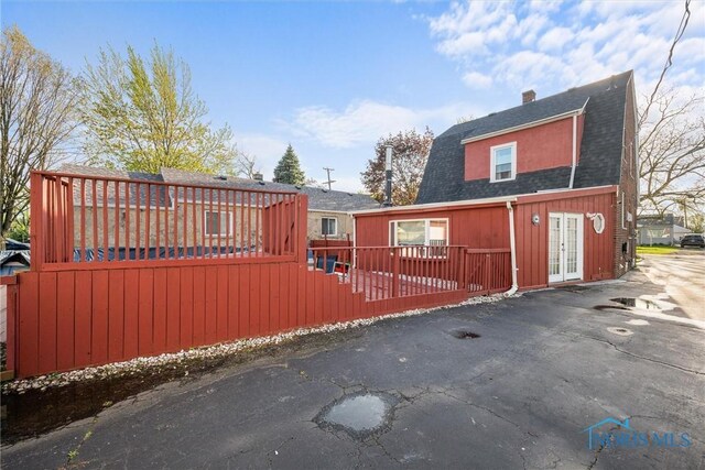 4532 290th St, Toledo, OH 43611 - view of front of home featuring a wooden deck, roof with shingles, french doors, and a chimney