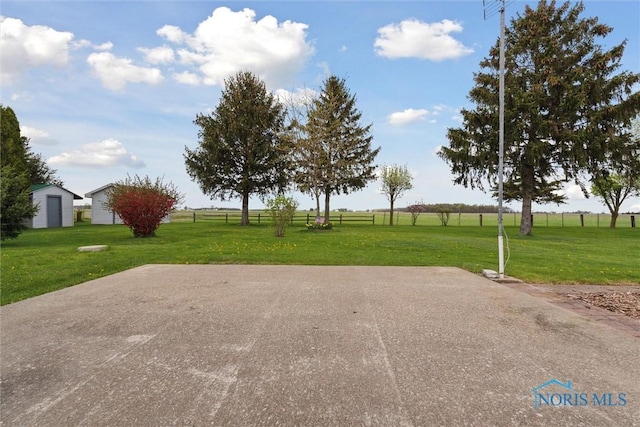 view of community featuring fence and a lawn