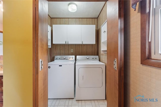 laundry area with washer and dryer, cabinet space, and light floors