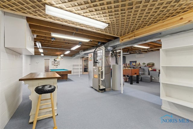 finished below grade area featuring water heater, heating unit, and billiards