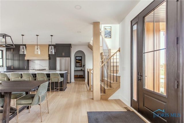 dining area featuring stairway, visible vents, plenty of natural light, and arched walkways