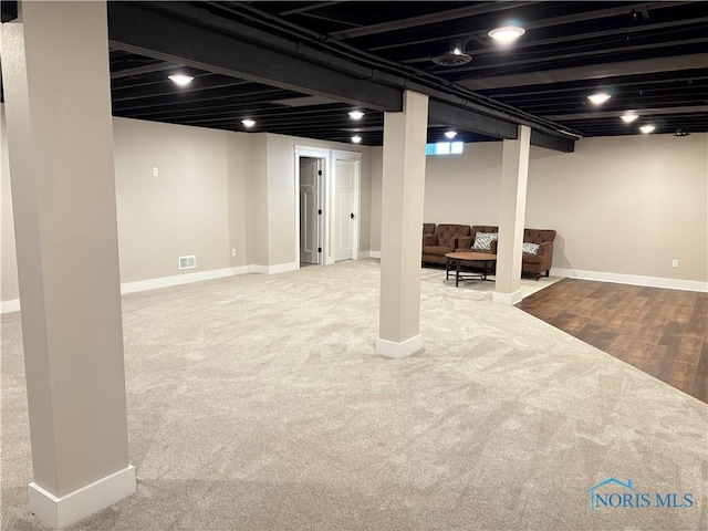 finished below grade area with visible vents, carpet floors, and baseboards