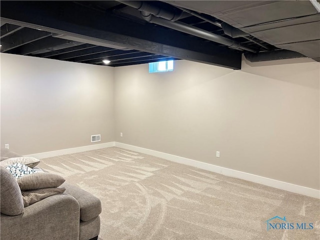 below grade area with carpet, visible vents, and baseboards