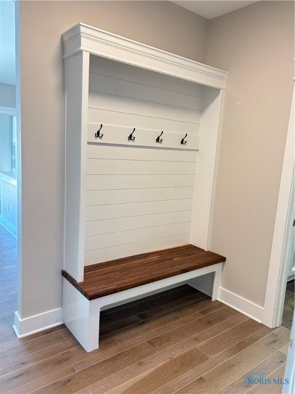 mudroom with wood finished floors and baseboards