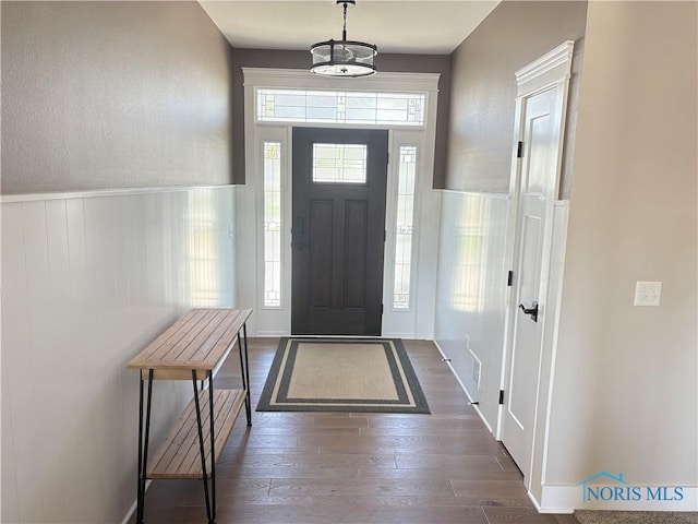 entryway with a wainscoted wall and dark wood finished floors