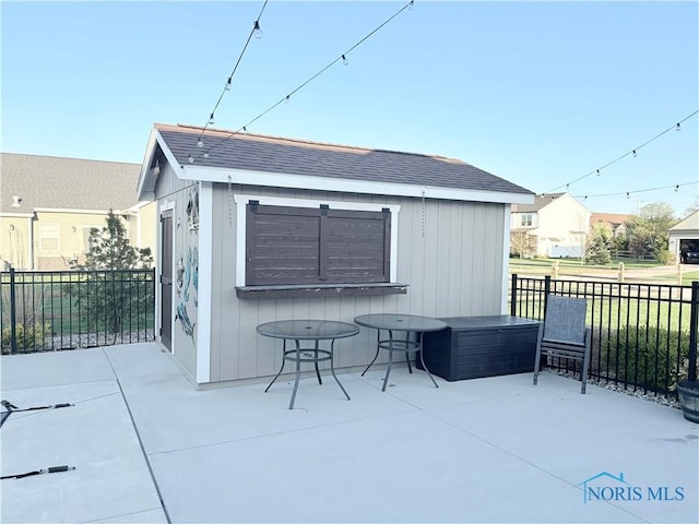 view of patio featuring fence and an outdoor structure