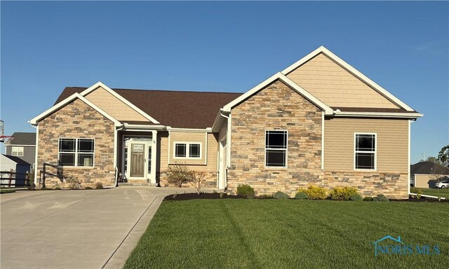 craftsman-style home featuring a front yard and stone siding
