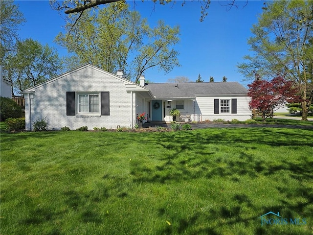 single story home with a chimney and a front yard