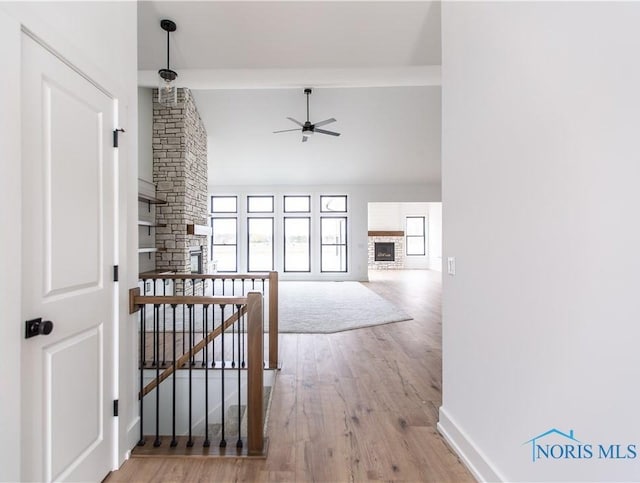 hallway featuring lofted ceiling, wood finished floors, an upstairs landing, and baseboards