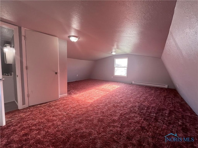 additional living space with a textured ceiling, baseboard heating, vaulted ceiling, and carpet floors