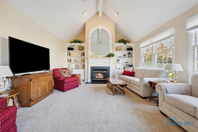 living room featuring carpet, ceiling fan, beam ceiling, high vaulted ceiling, and a fireplace with flush hearth