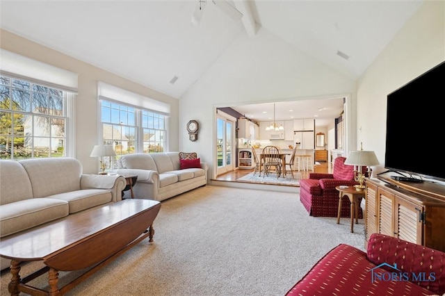 living area featuring carpet flooring, a notable chandelier, high vaulted ceiling, and beam ceiling
