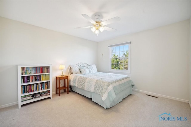 carpeted bedroom with baseboards, visible vents, and ceiling fan