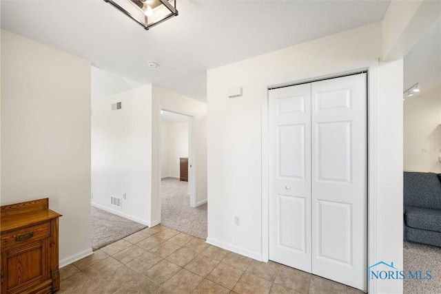 8 Zachary Cir, Waterville, OH 43566 - interior space featuring light tile patterned flooring, light carpet, baseboards, visible vents, and a closet