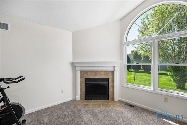 8 Zachary Cir, Waterville, OH 43566 - unfurnished living room featuring carpet flooring, visible vents, a healthy amount of sunlight, and a fireplace