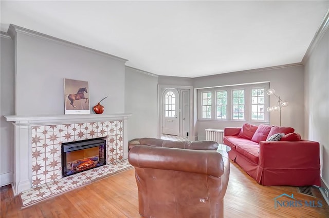 3533 Edgevale Rd, Ottawa Hills, OH 43606 - living room featuring wood finished floors, visible vents, a tiled fireplace, and crown molding
