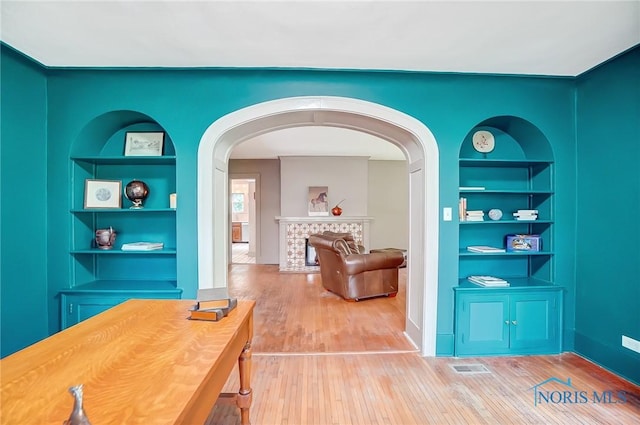 3533 Edgevale Rd, Ottawa Hills, OH 43606 - interior space featuring built in shelves, arched walkways, wood finished floors, and a fireplace