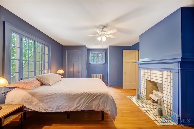 3533 Edgevale Rd, Ottawa Hills, OH 43606 - bedroom featuring radiator, a ceiling fan, light wood-style floors, and a fireplace