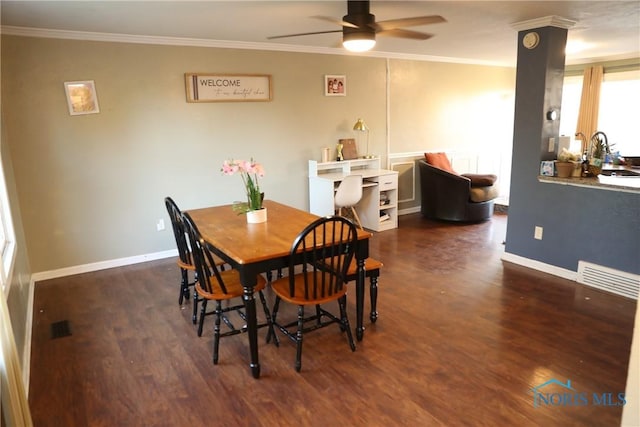 dining space featuring wood finished floors, a ceiling fan, and crown molding