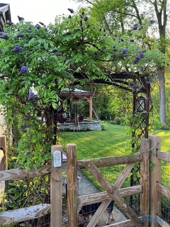 view of gate with a lawn
